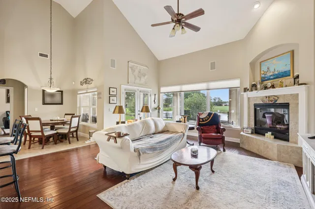 a living room with furniture fireplace and a large window