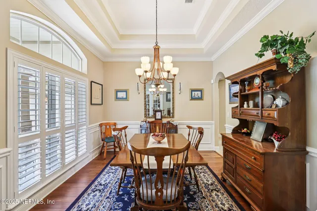 a dining room with furniture a chandelier and window