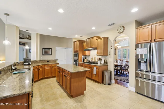 a large kitchen with a large counter top appliances and cabinets