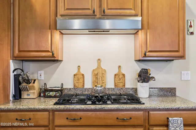 a kitchen with granite countertop stainless steel appliances stove and cabinets