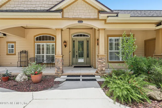 a front view of a house with potted plants