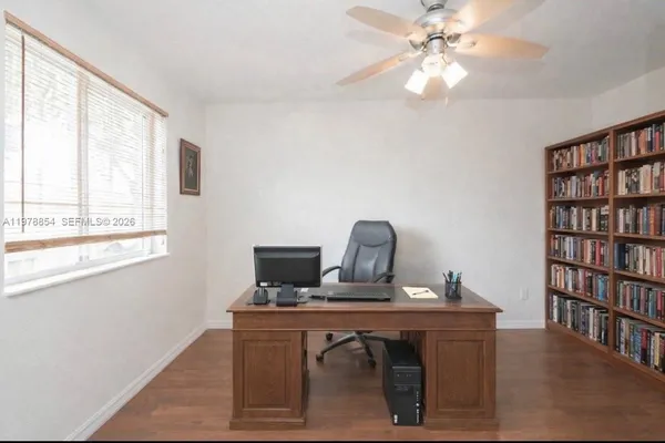 a view of a workspace with furniture and a window
