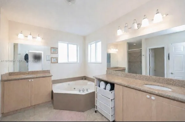 a bathroom with a tub sink and mirror