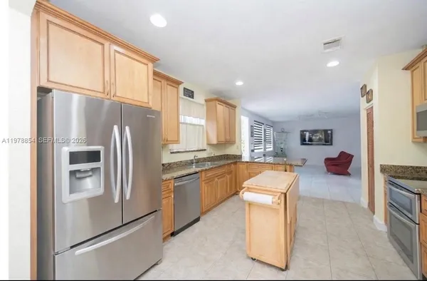 a kitchen with stainless steel appliances granite countertop a refrigerator and a stove