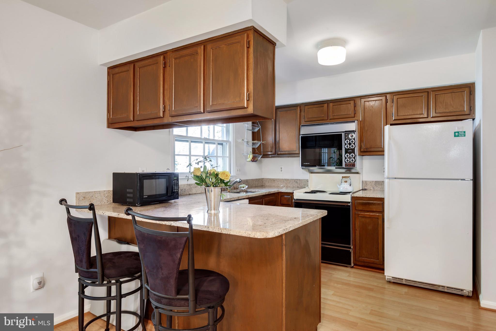 301 Crescendo Way Silver Spring, MD 20901 - Photo 14 of 30 a kitchen with stainless steel appliances granite countertop a stove top oven a refrigerator a sink and a microwave