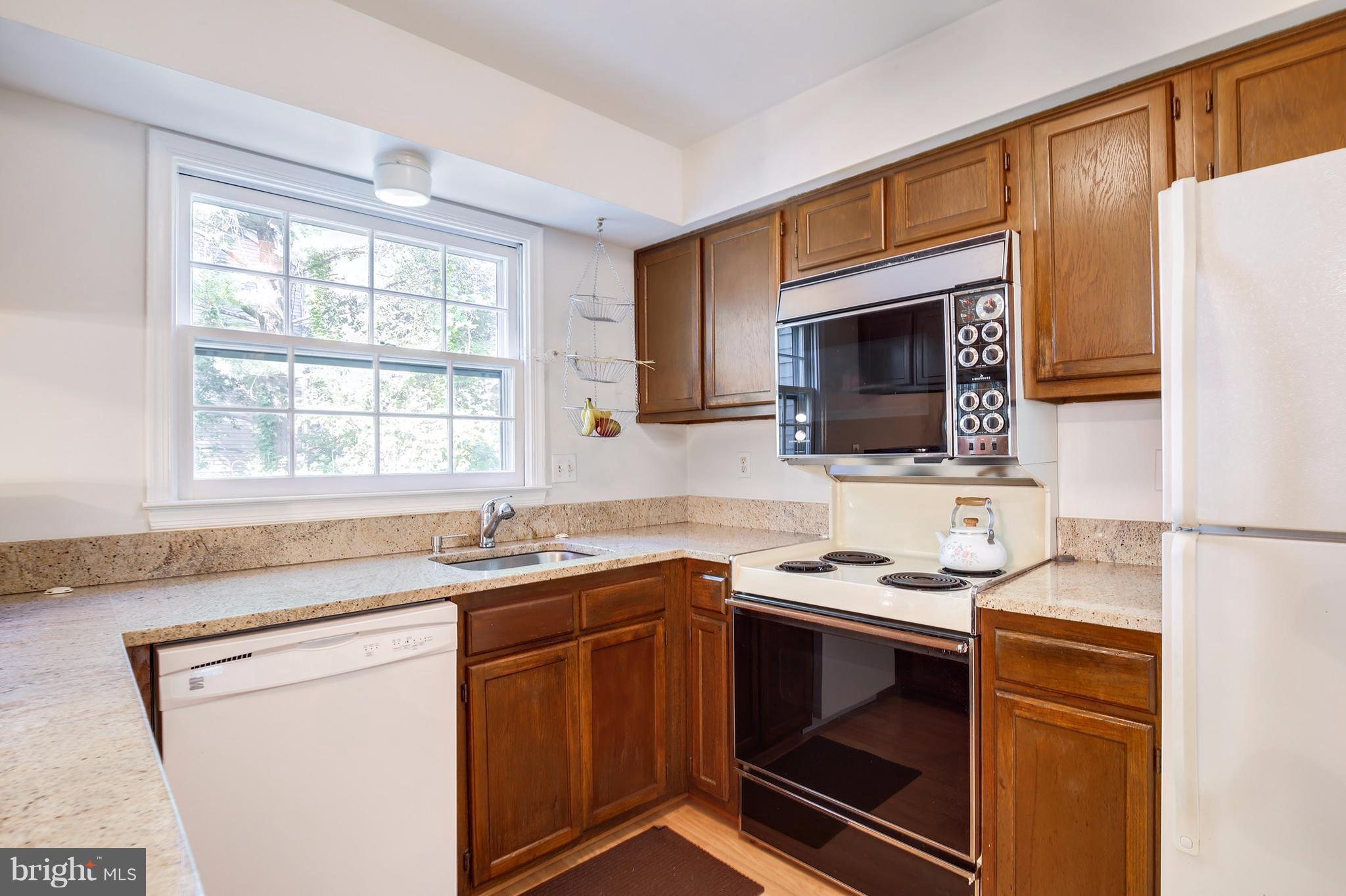 301 Crescendo Way Silver Spring, MD 20901 - Photo 17 of 30 a kitchen with stainless steel appliances a stove sink microwave and refrigerator