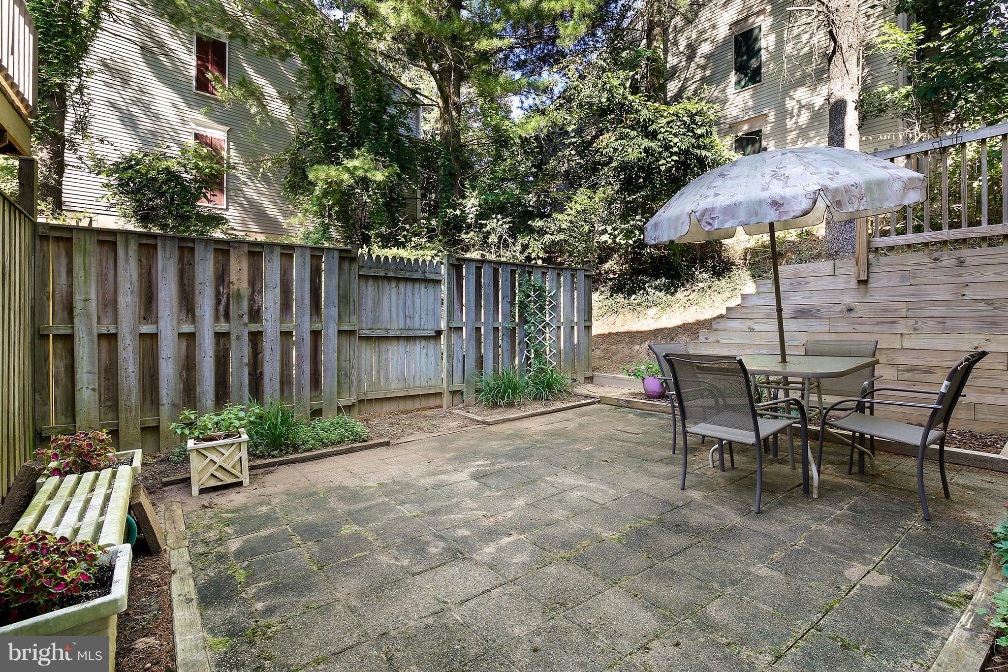 301 Crescendo Way Silver Spring, MD 20901 - Photo 28 of 30 a view of a tables and chairs under an umbrella in backyard