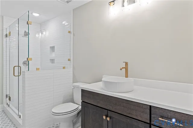 a bathroom with a sink a toilet a shower and a mirror