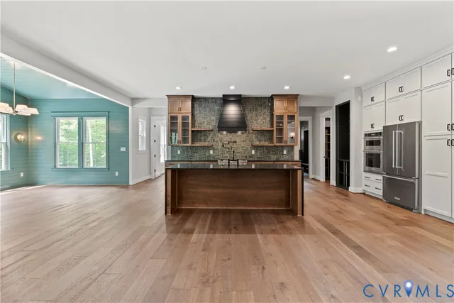 a large kitchen with stainless steel appliances kitchen island granite countertop a large counter top and stove top oven