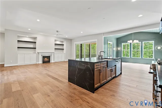 a kitchen with stainless steel appliances granite countertop a stove and a large window