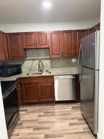 a kitchen with a refrigerator sink and cabinets