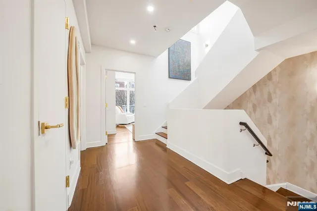 a view of hallway with wooden floor and stairs