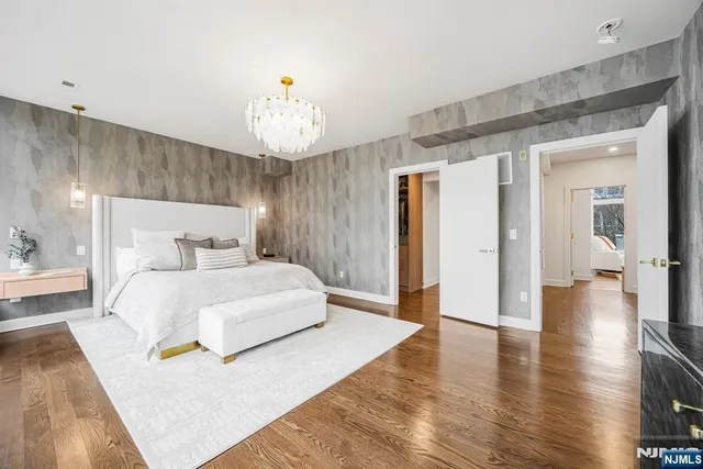 a spacious bedroom with a bed and a chandelier