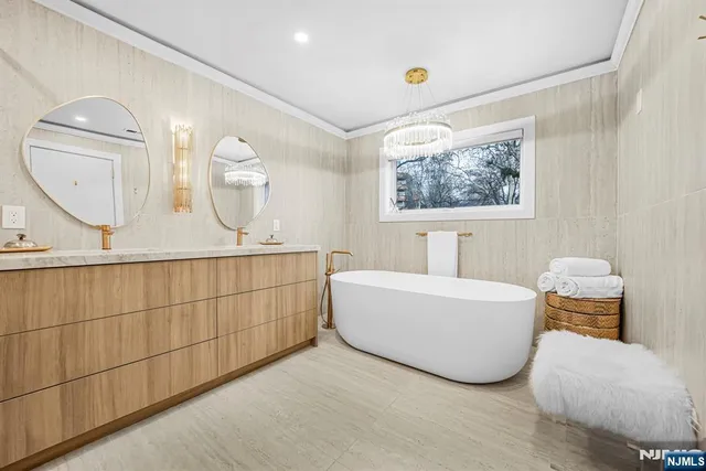 a bathroom with a double vanity sink mirror and bathtub