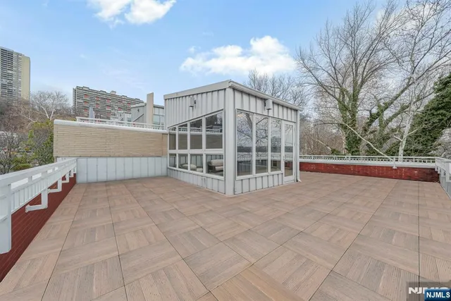 a view of roof deck with a barbeque and wooden stairs