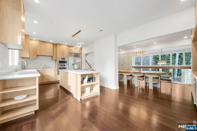 a large white kitchen with lots of counter space and stainless steel appliances