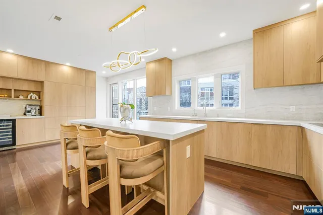 a kitchen with stainless steel appliances granite countertop a sink and a refrigerator
