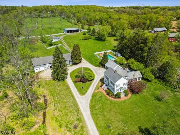 an aerial view of residential houses with outdoor space and trees