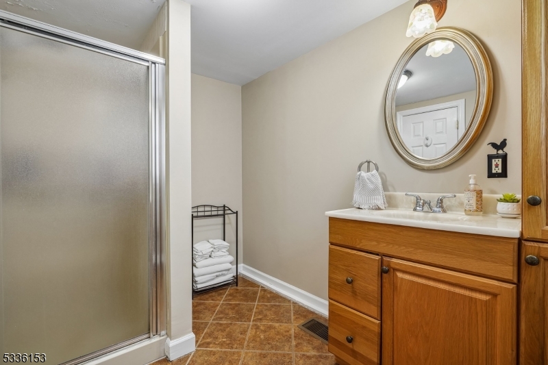 70 Pleasant Run Road Flemington, NJ 08822 - Photo 42 of 50 a bathroom with a granite countertop sink a mirror and a shower