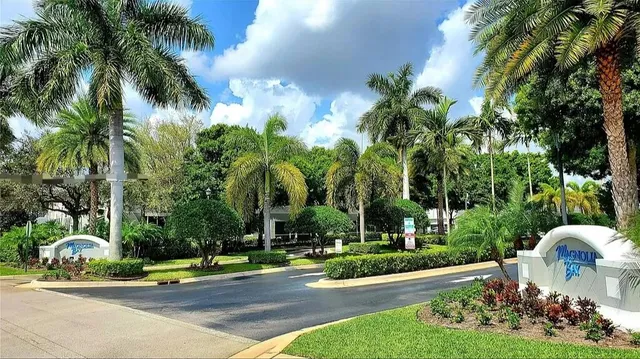 a front view of a house with garden and trees