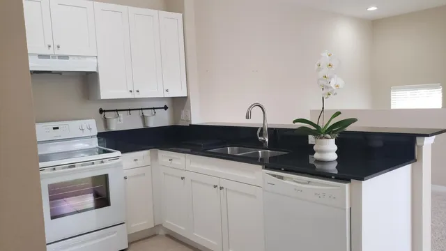a close view of a stove a sink and dishwasher with kitchen island