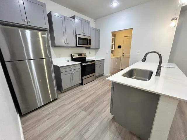 a kitchen with a refrigerator sink and stove