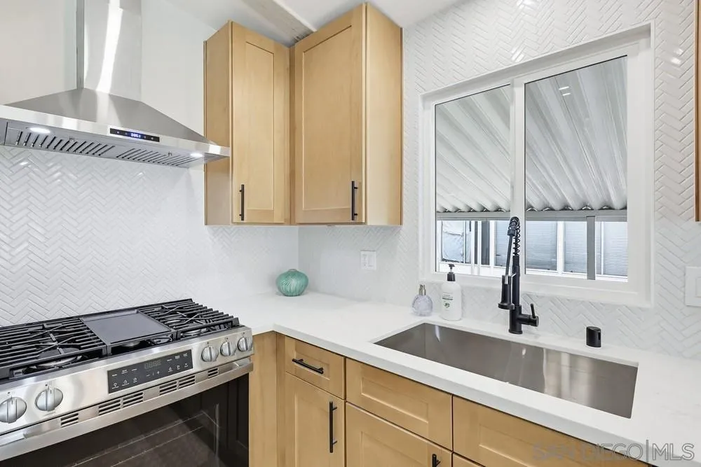 11949 Riverside Drive, Unit 23 Lakeside, CA 92040 - Photo 14 of 27 a kitchen with stainless steel appliances a sink a stove and white cabinets