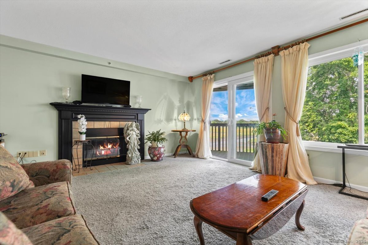 2 Mansfield Grove Road, Unit 262 East Haven, CT 06512 - Photo 2 of 47 In the living room you will find a wood burning fireplace to keep you cozy and warm in the cooler weather.