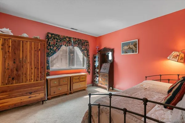a room with a chair and potted plant