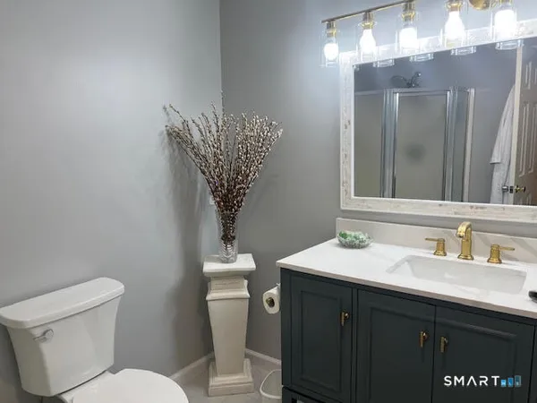a bathroom with a toilet sink and mirror