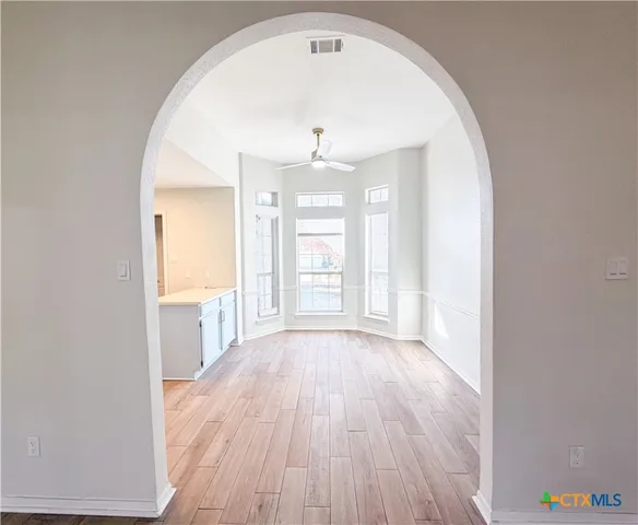 a open kitchen with granite countertop white cabinets and white appliances