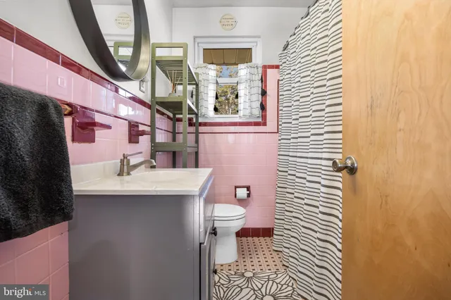 a bathroom with a sink a toilet and a mirror