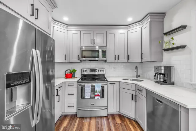a kitchen with stainless steel appliances a stove refrigerator sink and cabinets