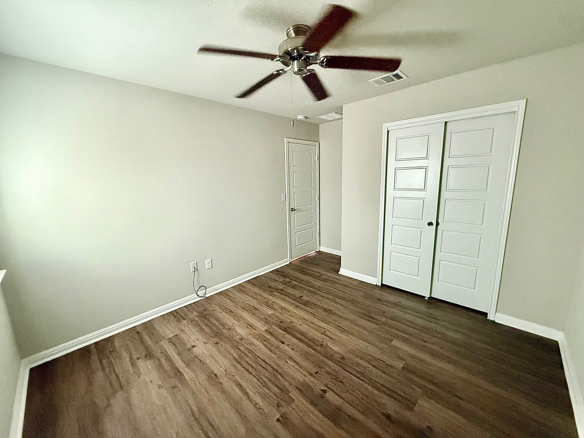 513 Longhorn Cavern Road Leander, TX 78641 - Photo 15 of 24 Unfurnished bedroom featuring dark wood finished floors, ceiling fan, and a closet
