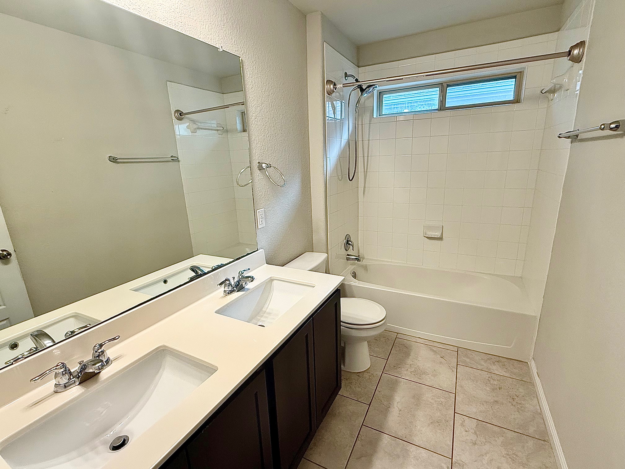 513 Longhorn Cavern Road Leander, TX 78641 - Photo 16 of 24 Full bathroom featuring double vanity, bathing tub / shower combination, a textured wall, and light tile patterned floors