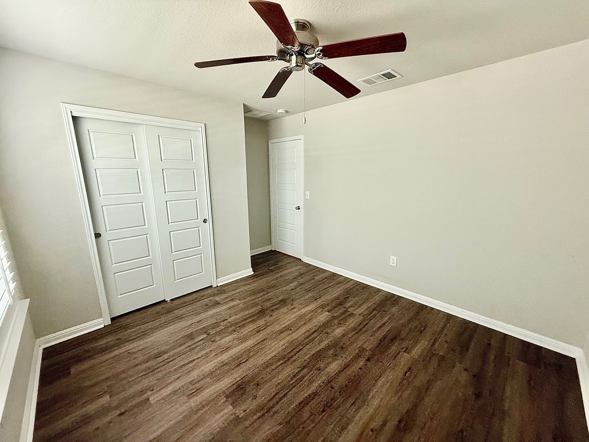 513 Longhorn Cavern Road Leander, TX 78641 - Photo 18 of 24 Unfurnished bedroom with a closet, dark wood-style floors, a ceiling fan, and a textured ceiling