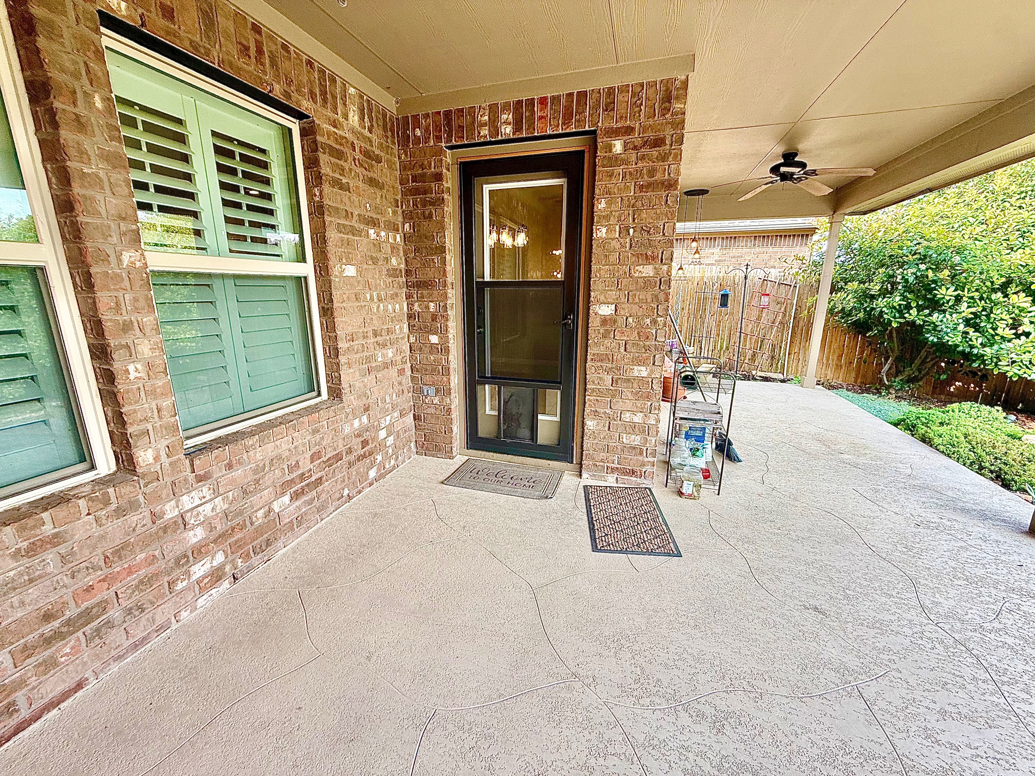 513 Longhorn Cavern Road Leander, TX 78641 - Photo 21 of 24 Back Doorway to property featuring ceiling fan, screened pet door, brick siding, and a patio