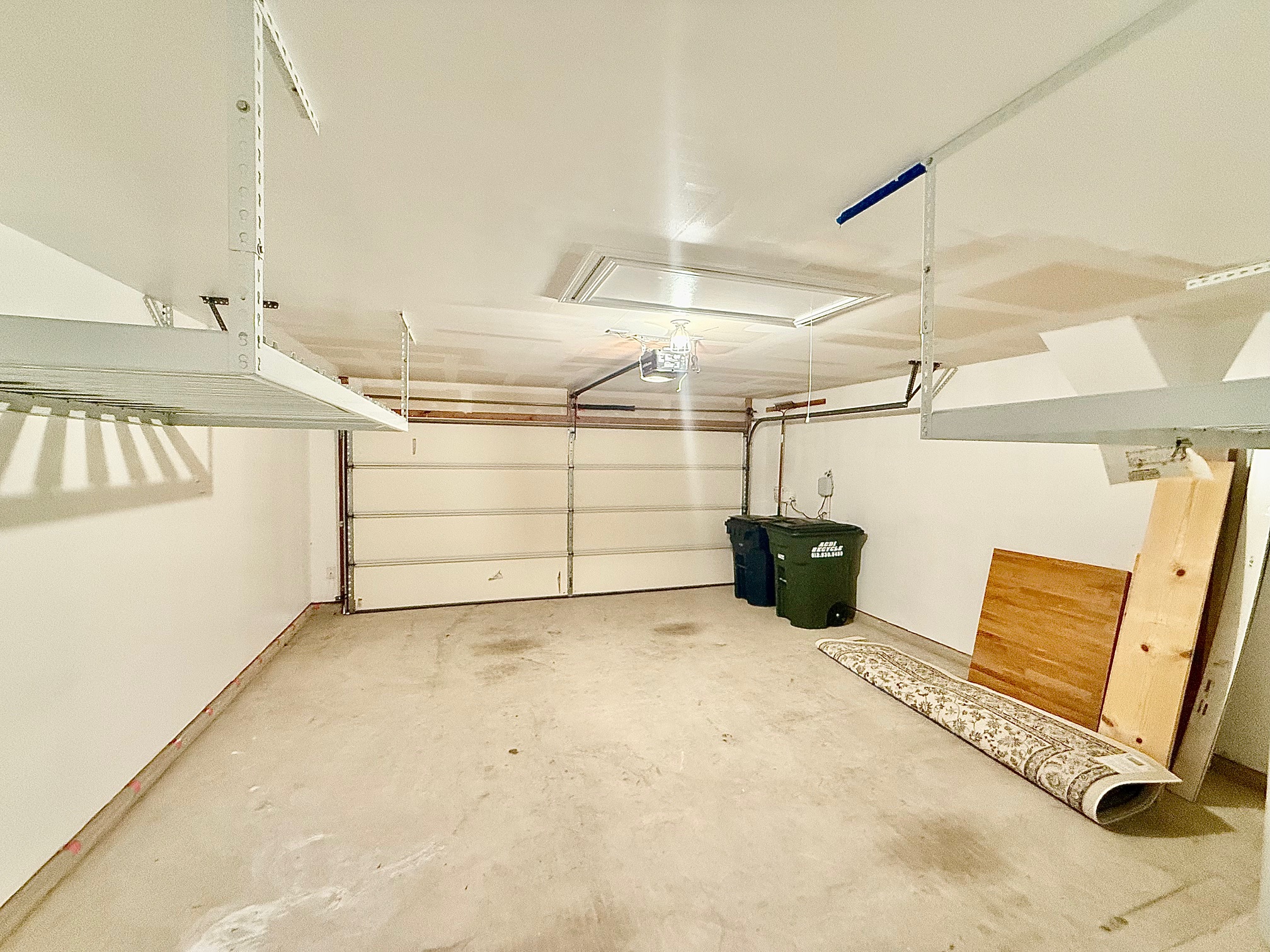 513 Longhorn Cavern Road Leander, TX 78641 - Photo 22 of 24 Garage featuring a garage door opener, storage racks, water softener