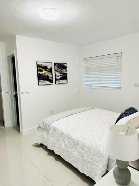1030 Northeast 80th Street, Unit 4 Miami, FL 33138 - Photo 12 of 28 a bedroom with a bed and a painting on the wall