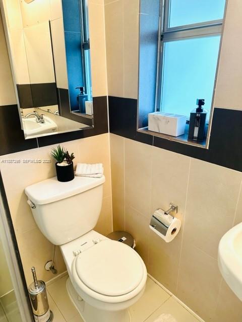 1030 Northeast 80th Street, Unit 4 Miami, FL 33138 - Photo 16 of 28 a bathroom with a toilet sink and mirror
