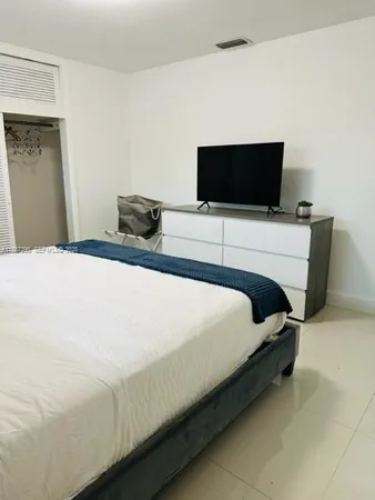 a bedroom with a bed and a flat screen tv