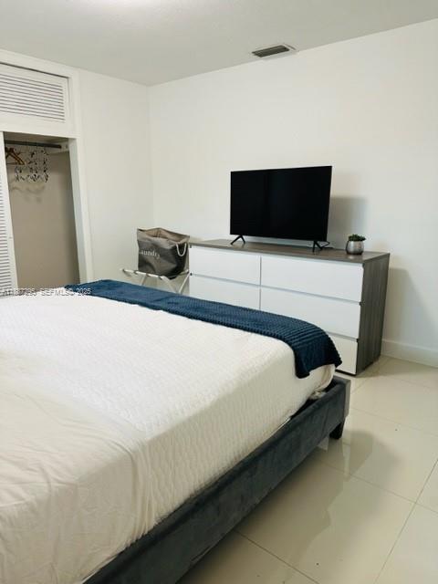 1030 Northeast 80th Street, Unit 4 Miami, FL 33138 - Photo 21 of 28 a bedroom with a bed and a flat screen tv