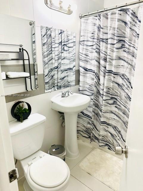 1030 Northeast 80th Street, Unit 4 Miami, FL 33138 - Photo 22 of 28 a bathroom with a sink a toilet and shower curtain