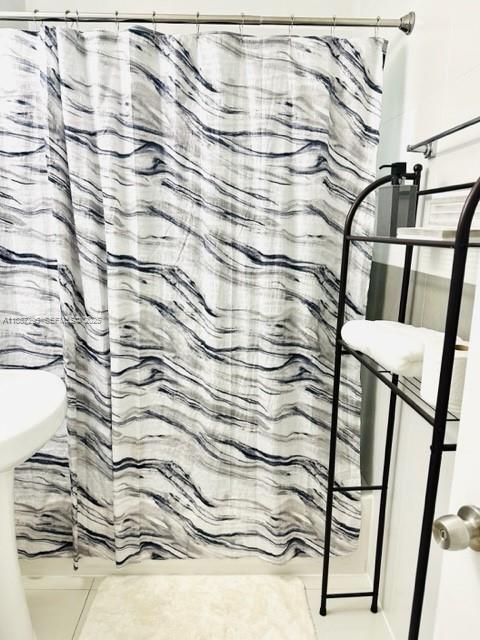 1030 Northeast 80th Street, Unit 4 Miami, FL 33138 - Photo 23 of 28 a bathroom with a shower curtain and a sink