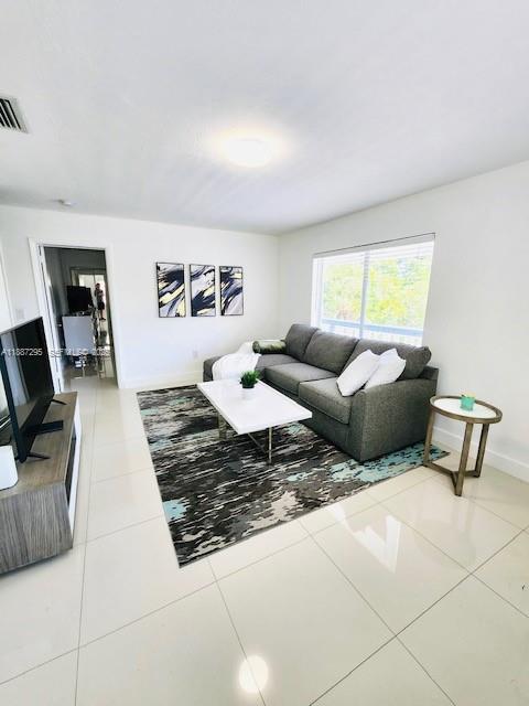 1030 Northeast 80th Street, Unit 4 Miami, FL 33138 - Photo 3 of 28 a living room with furniture and a flat screen tv