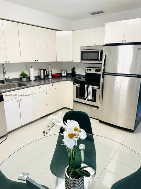 1030 Northeast 80th Street, Unit 4 Miami, FL 33138 - Photo 8 of 28 a kitchen with stainless steel appliances granite countertop a sink a stove a microwave a refrigerator and cabinets