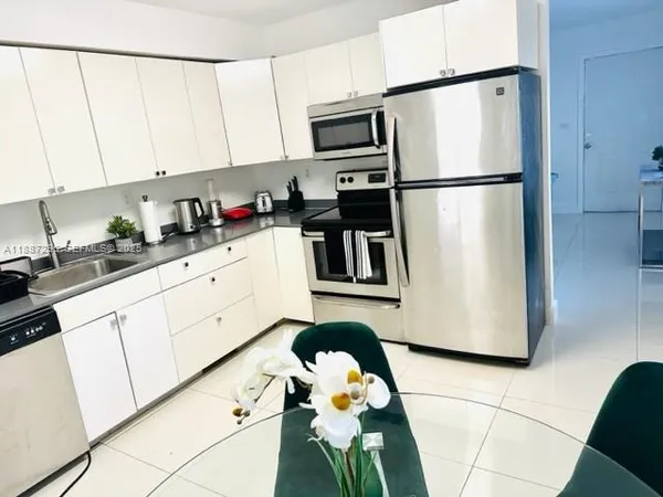 a kitchen with stainless steel appliances a refrigerator sink and cabinets