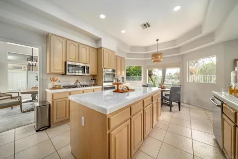 a kitchen with appliances a sink a counter and chairs