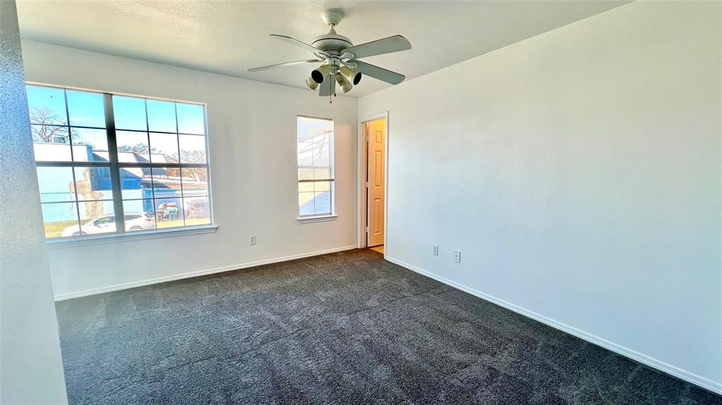 4503 Fortuna Street Fort Worth, TX 76119 - Photo 13 of 26 an empty room with windows and ceiling fan