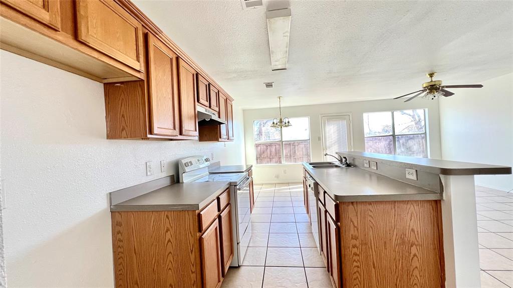 4503 Fortuna Street Fort Worth, TX 76119 - Photo 5 of 26 a kitchen with stainless steel appliances granite countertop a sink and a refrigerator